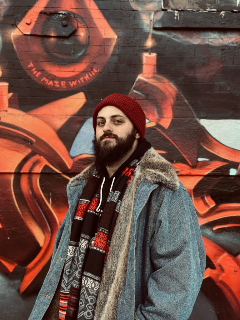 Jonas Loeb standing in front of a graffiti mural